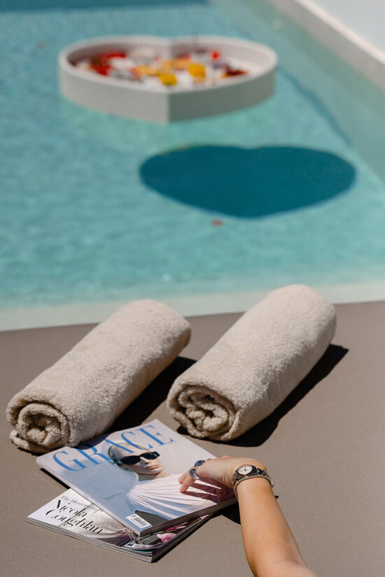 A magazine and two towels by the pool at the Omna Caldera Suites in Santorini.