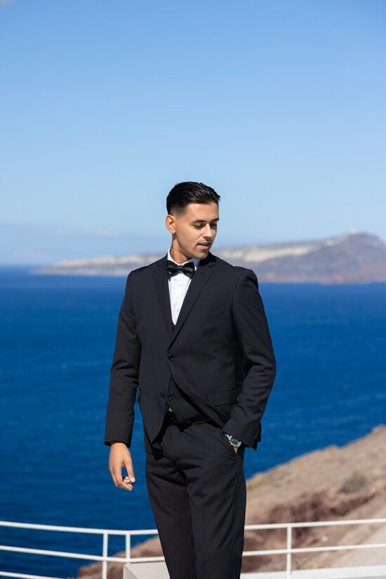 A groom in a black costume at the Omna Caldera Suites with sea views in Santorini.
